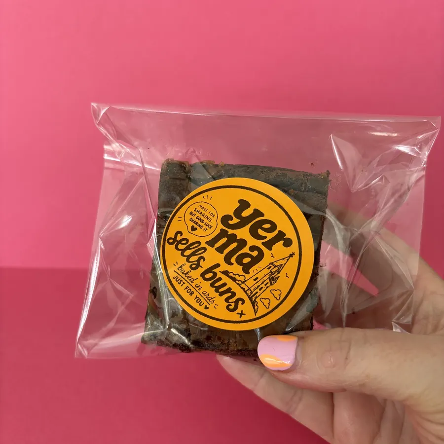 A brownie bagged up with the Yer Ma Sells Buns sticker